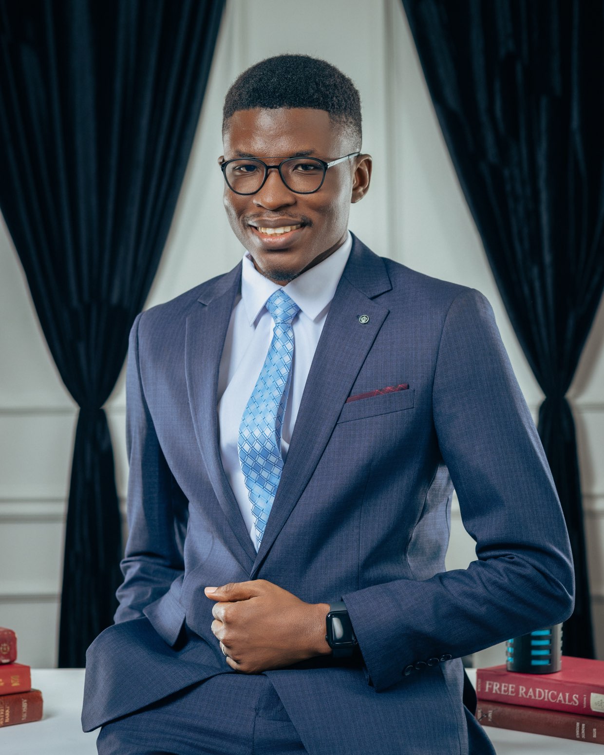 Isaac Anyimiah, in a navy suit and blue tie