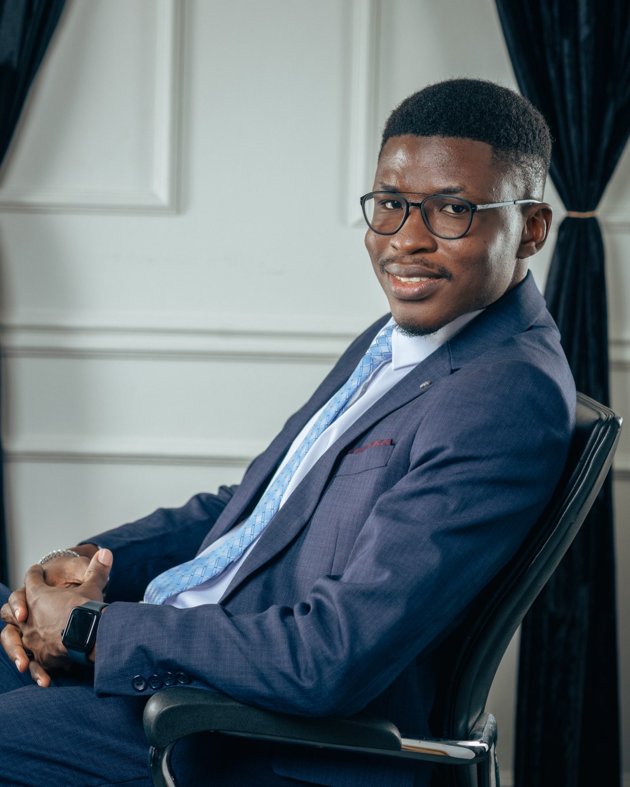 Isaac Anyimiah, seated, in a navy suit